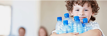 A Young Smiling Boy Holds Bottles of Water